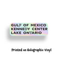 Holographic sticker that says "Gulf of Mexico," "Kennedy Center," and "Lake Ontario," highlighting the letters FDT for Fuck Donald Trump.