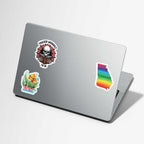 Laptop with various stickers on a light gray background
