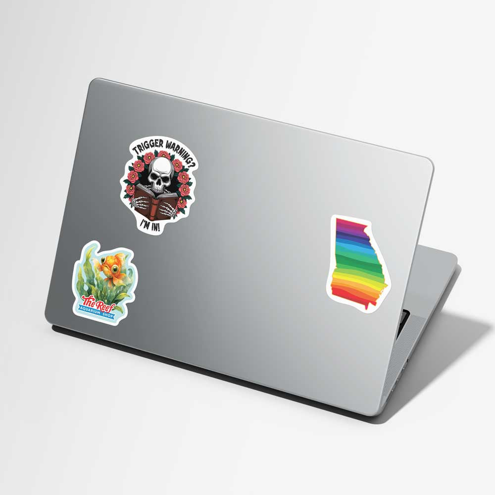 Laptop with various stickers on a light gray background